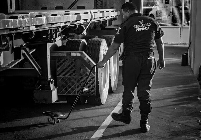 Guardia de seguridad industrial inspeccionando un camión